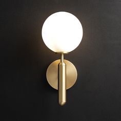 a light that is on the side of a wall mounted fixture with a white ball