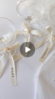 three wine glasses with ribbons tied around them on a white table cloth, and the words pretty written in black