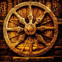 an intricately carved wheel on the side of a building