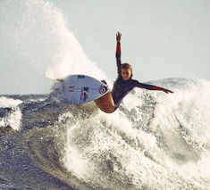 a man riding a wave on top of a white surfboard in the middle of the ocean