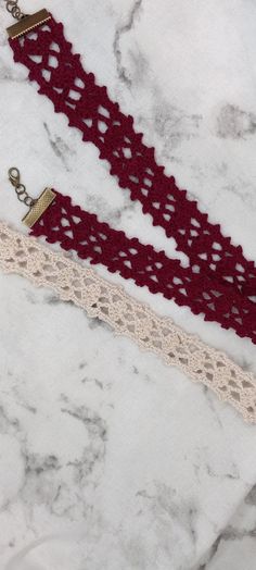 two crocheted garters on top of a marble counter with gold chains