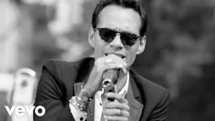 a man wearing sunglasses and holding a microphone