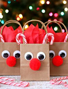 some paper bags decorated like reindeers with candy canes