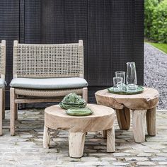 two wooden tables sitting next to each other on top of a stone floor covered ground