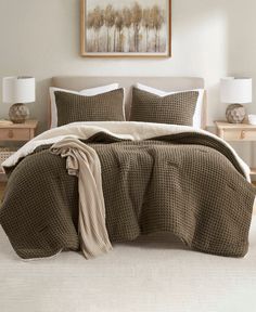 a bed with brown and white comforters in a bedroom