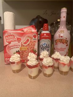 cupcakes with whipped cream on them next to bottles of booze