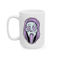 a white coffee mug with an image of a screamy face on the front and purple hair