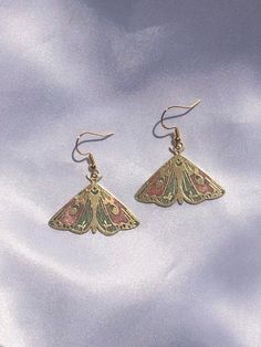 Shimmery pastel pink, green, and cream resin in a brass moth shaped setting. Golden hypoallergenic earring hooks are made of 925 silver-plated copper. Each piece is handmade and is created by carefully pouring and mixing resin into each individual section. This tedious process leads to beautiful vibrant colors that imitate a stained glass look in a much more durable and lightweight way. Every piece is naturally unique as it is impossible to maintain the pigment to resin ratio, leading to large v Green Moth, Moth Earrings, Luna Moth, Butterfly Wing, Rose Pastel, Funky Jewelry, Jewelry Lookbook, Hypoallergenic Earrings, Girly Jewelry