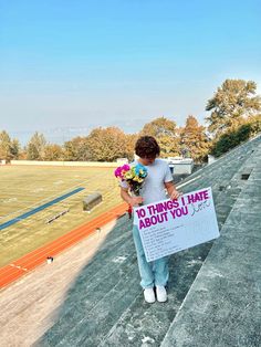 a woman holding flowers and a sign that says 10 things i hate about you on it