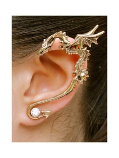 a close up of a person's ear with a dragon design on it