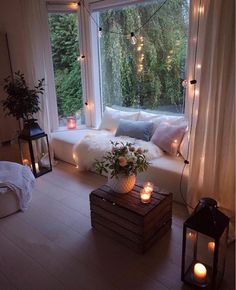 a living room filled with lots of furniture next to a large window covered in lights