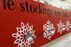 a red sign with white snowflakes on it that says the stockings were hung