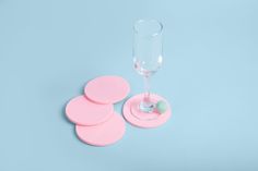 pink coasters and a wine glass on a blue background