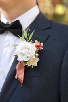 a man in a tuxedo wearing a boutonniere with flowers on it