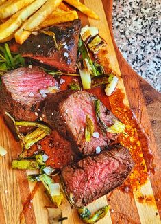 steak and french fries on a wooden cutting board