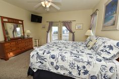 a bedroom with a bed, dresser and television