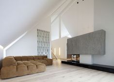 a living room with white walls and wood flooring is pictured in this image, there are two couches facing each other