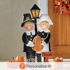 a couple of people standing next to each other in front of a door with pumpkins