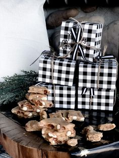 a stack of cookies sitting on top of a wooden table next to a black and white present box