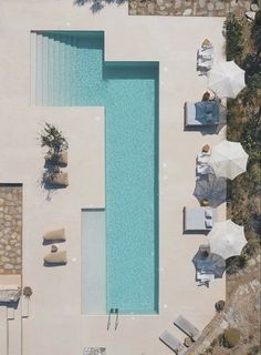 an aerial view of a pool with umbrellas and chairs