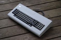 an old computer keyboard sitting on top of a wooden table