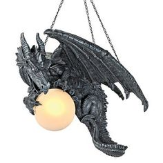 a black dragon hanging from a chain with a light on it's back end