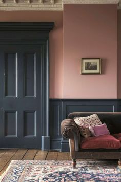 a living room with pink walls and blue doors