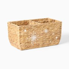 a wicker basket with white snowflakes on the front and sides, sitting against a white background