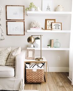 a living room filled with white furniture and pictures on the wall above it's bookshelves