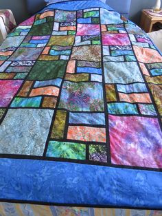 a bed with a colorful quilt on top of it