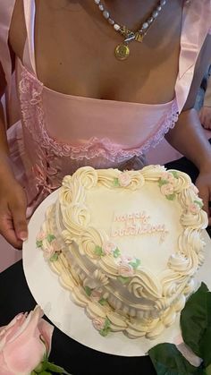 a woman in a pink dress is holding a cake with the words happy birthday written on it