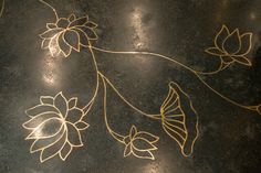 the floor is decorated with gold flowers and butterflies on black marble, which has been hand - painted