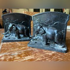 two elephant figurines sitting on top of a wooden table