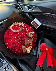 a bouquet of red roses in the back seat of a car with a butterfly brooch on it