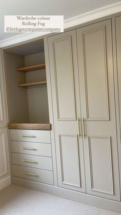 an empty walk in closet with white cabinets and wood trimmings on the doors