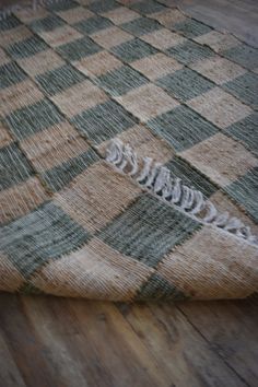 a close up of a checkered rug on the floor with an odd shaped object