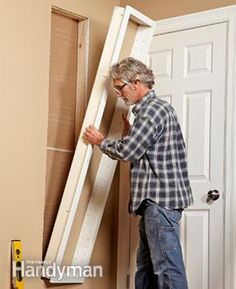 a man standing in front of a white door with a window pane on it