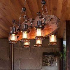 a chandelier with five lights hanging from it's sides and wood plank ceiling