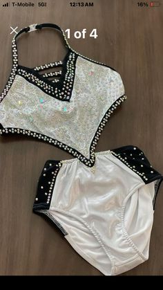 two pieces of white and black swimsuit with silver beads on the bottom, one piece is