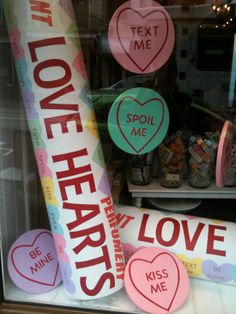 there is a display in the window with hearts on it and words that spell love