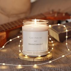 a candle that is sitting on a table next to some string lights and a guitar