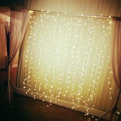 the backdrop is covered with lights and draping for a wedding or special event