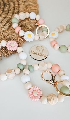 a bunch of beads are laying on the table next to a flower and a pair of scissors