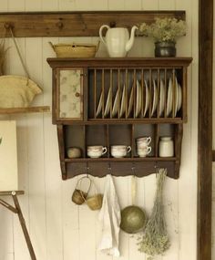 a wooden shelf filled with dishes and cups