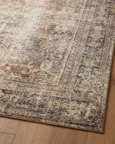 an area rug on the floor with wood floors and a wooden floor in front of it