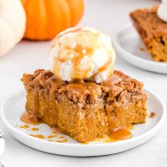 there is a piece of cake on the plate with ice cream and pumpkins in the background