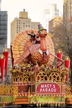 an elaborate float in the macy's parade, with large turkey on top and two red fire extinguishers