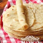 a stack of tortillas sitting on top of a red and white checkered table cloth