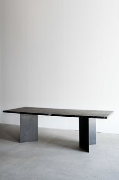 a black table sitting in the middle of a room next to a white wall and floor