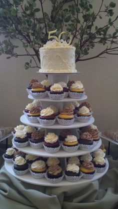 a wedding cake and cupcakes are stacked on top of each other